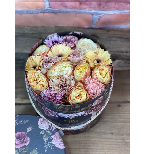 Composizione di fiori freschi misti, in scatola cilindrica decorativa, con motivo floreale